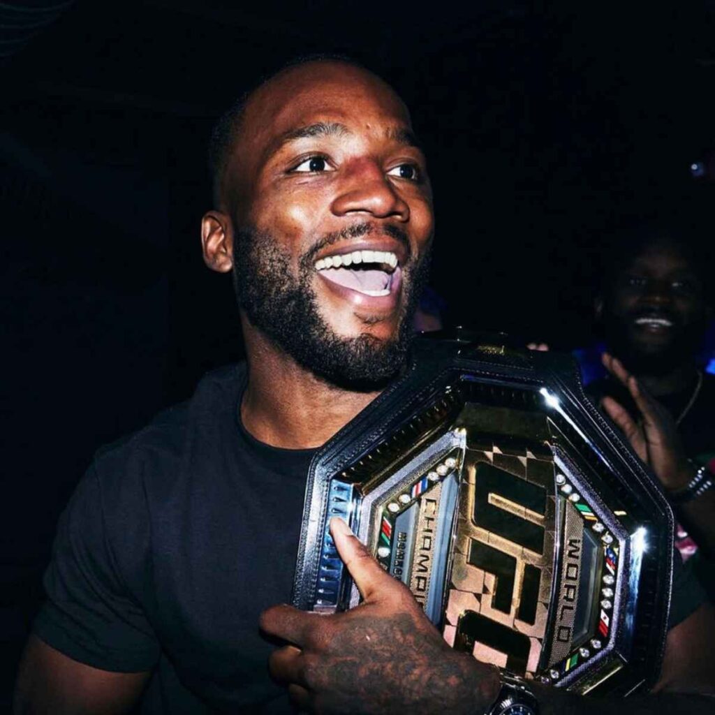 Leon Edwards holding the UFC welterweight belt and smiling